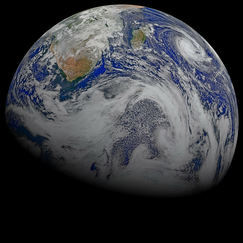 A view of Earth from space, showcasing the southern hemisphere with visible land masses, oceans, and swirling cloud patterns.